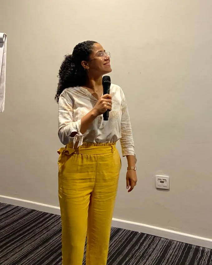 Erika Nascimento, psicanalista, falando ao microfone durante uma palestra