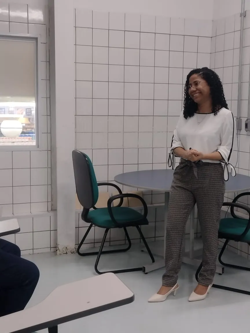 Erika Nascimento sorrindo durante um atendimento em grupo